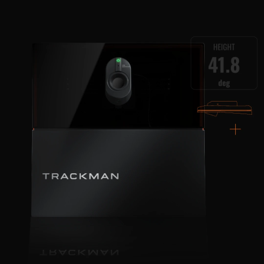 Trackman device with glowing green light, displaying "HEIGHT 41.8 deg" on a dark background, highlighting its sleek design.