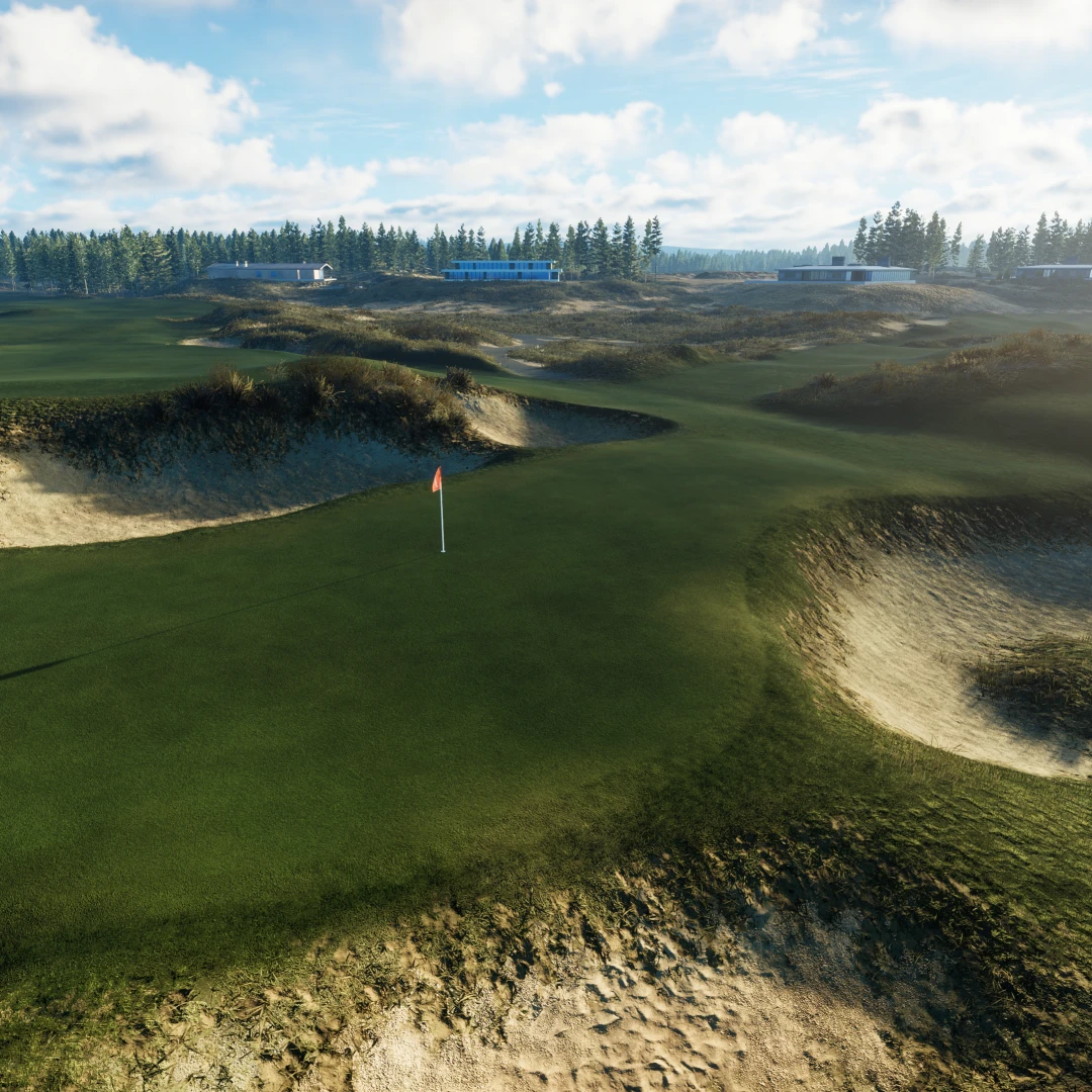 A picturesque golf course with rolling green hills, sandy bunkers, a red flag on the putting green, and pine trees under a partly cloudy sky.