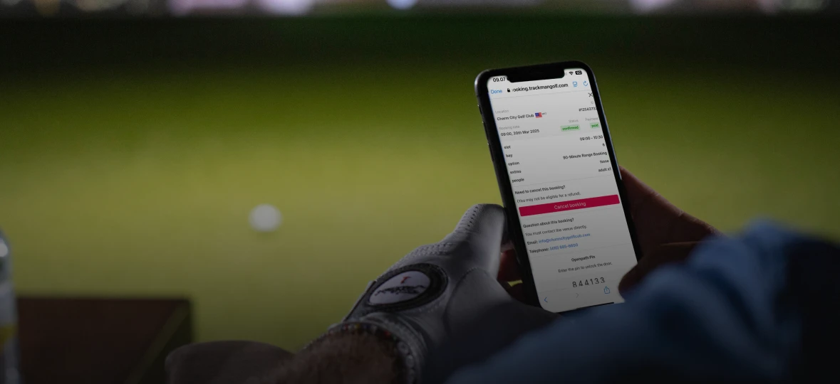 Person wearing a golf glove viewing a golf booking confirmation on a smartphone.